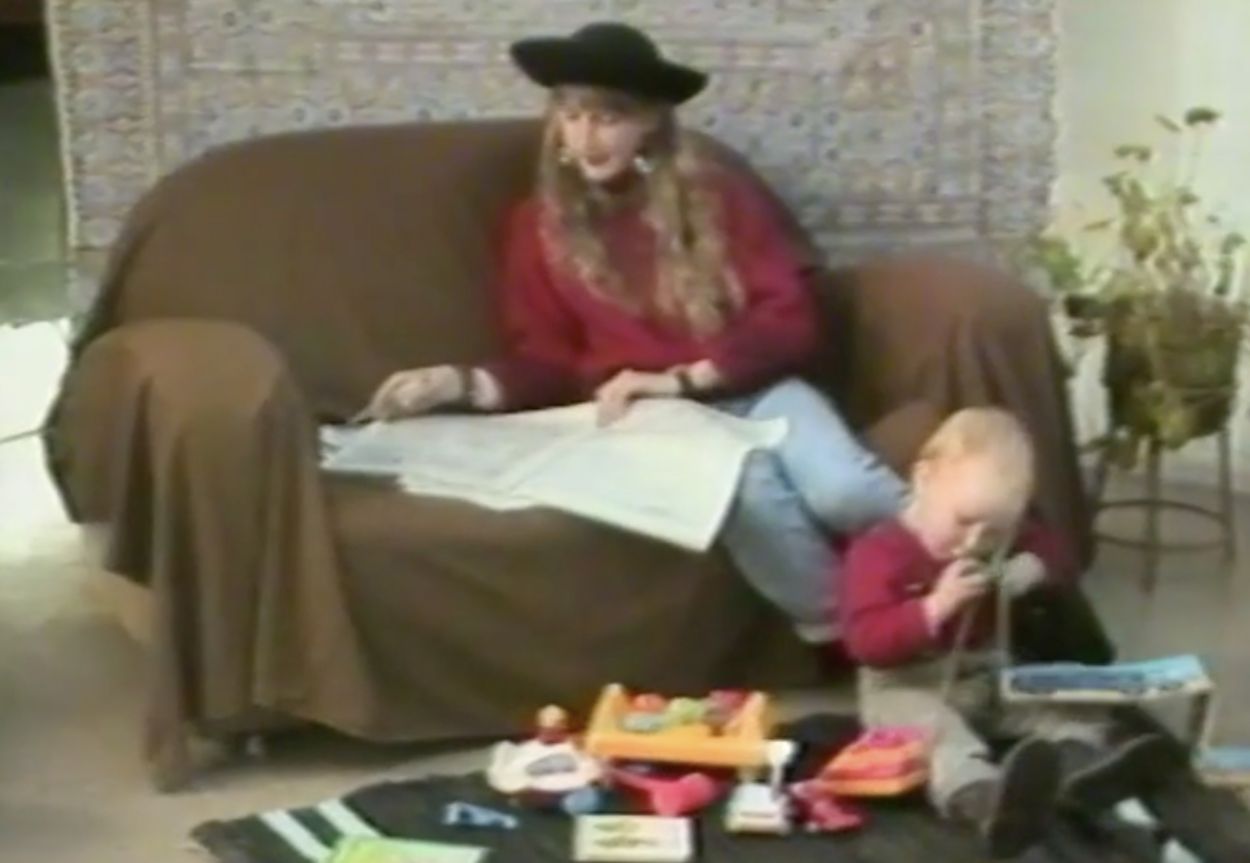 woman on a sofa with a child playing with a telephone.