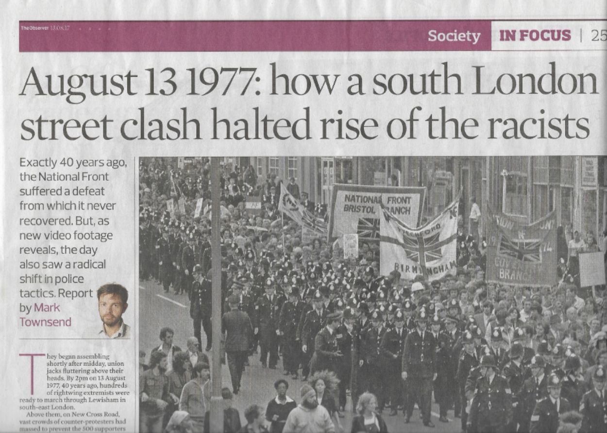 Newspaper page. Typed headline with black and white image of crowd marching.