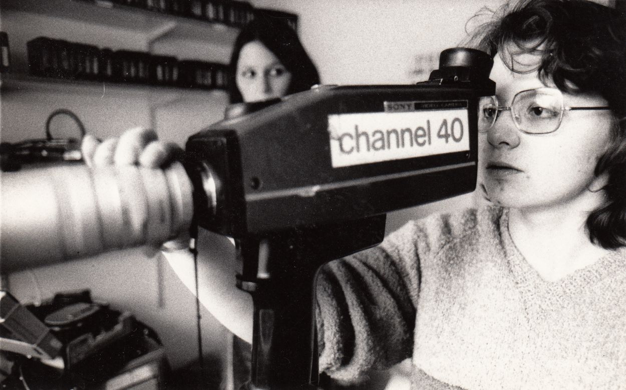 woman holding a camera with channel 40 sticker.