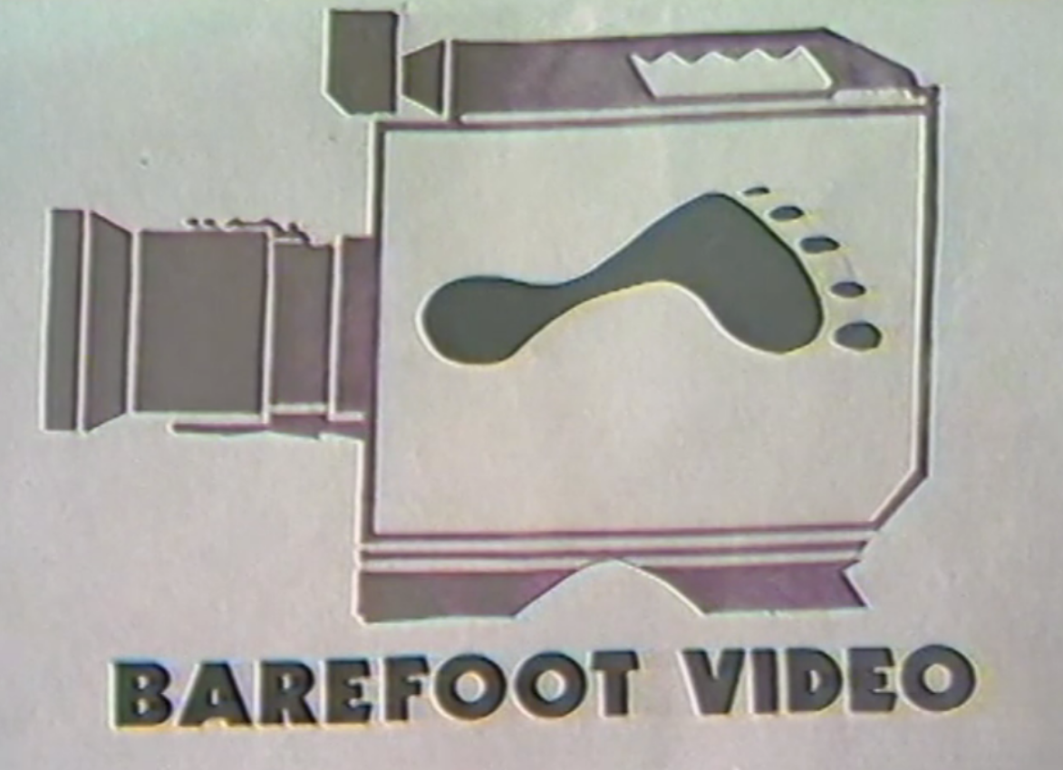 Black and white logo. Simple block image of video camera with barefoot outline inside.